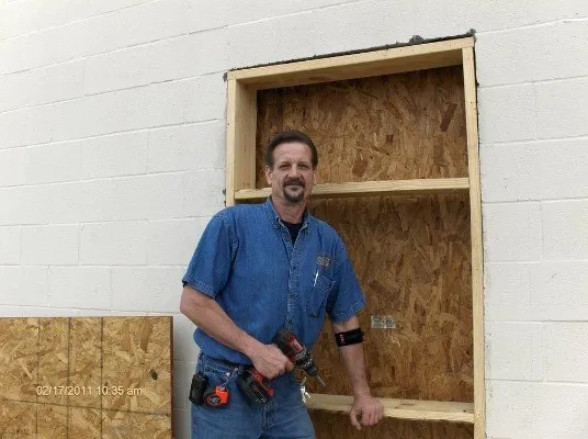 Man repairing wooden door frame